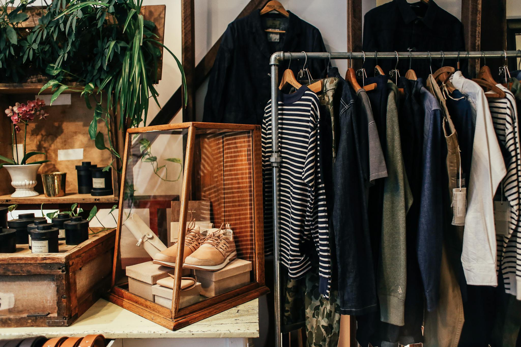 A stylish boutique clothing rack featuring diverse apparel and accessories in a cozy, natural setting.