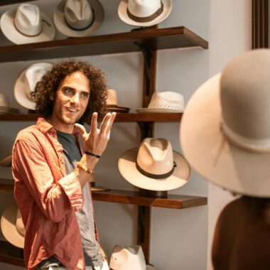 A stylish couple in a boutique browsing and trying on hats. Fashionable shopping scene.